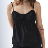 Black camisole worn by a person on a white background