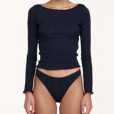 A model wearing a dark navy blue ribbed long-sleeve crop top and matching high-waisted underwear against a plain light background.