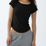 Woman wearing a black t-shirt and gray pants on a white background