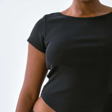 Person wearing a black top with a plain background