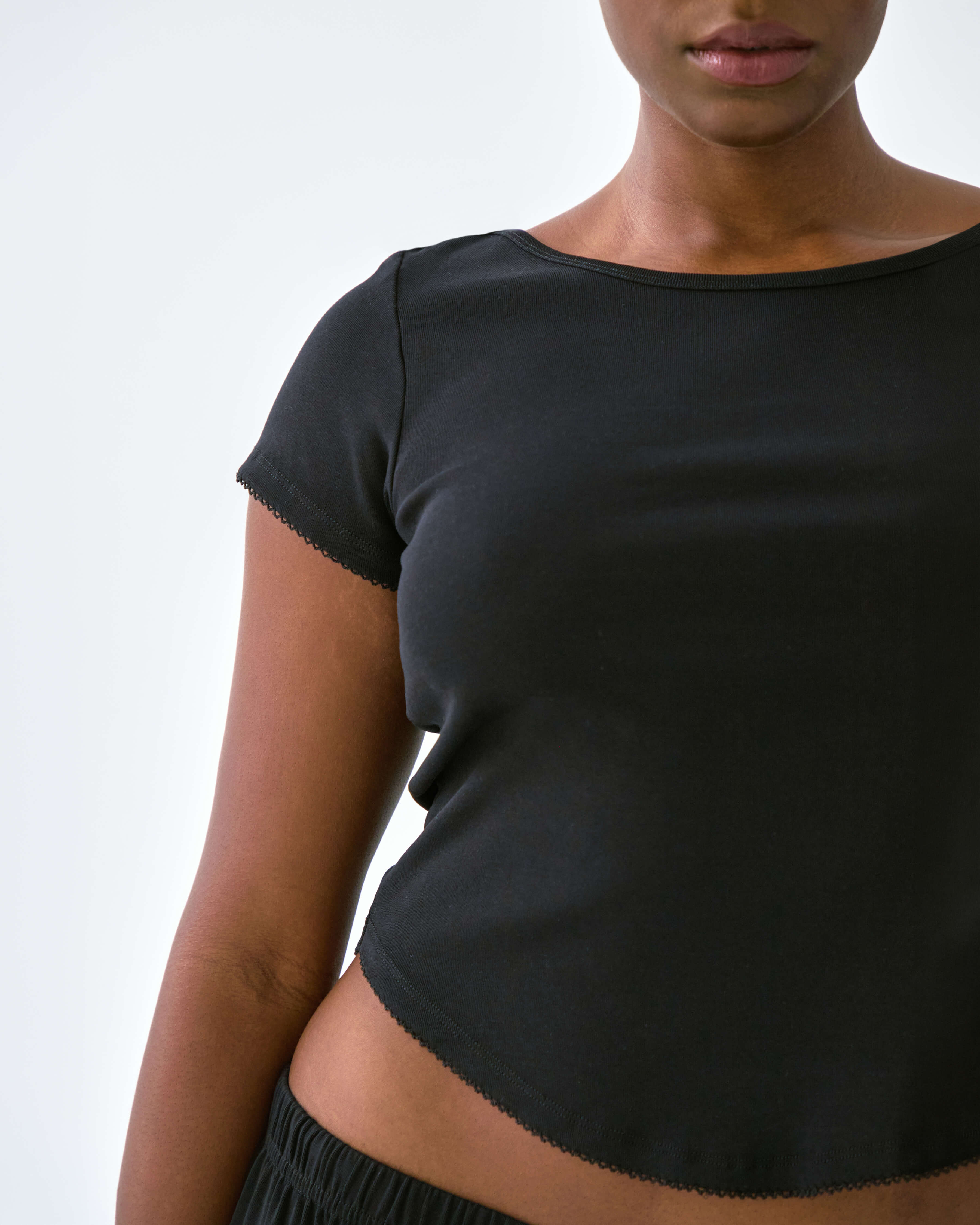 Person wearing a black top with a plain background