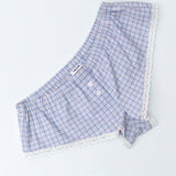 Blue checkered boxer shorts with lace trim on a light gray background
