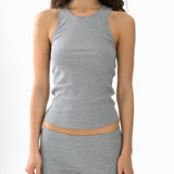 Woman wearing a gray tank top and shorts set on a white background
