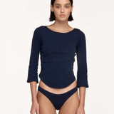 A model wearing a navy blue three-quarter sleeve swim top and matching underwear.