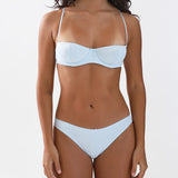 Woman wearing a light blue underwear set on a white background