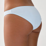 Light blue briefs worn by a person on a plain background