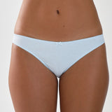 Light blue briefs worn by a person on a plain background