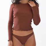 Woman wearing a brown long-sleeve top and matching underwear on a white background