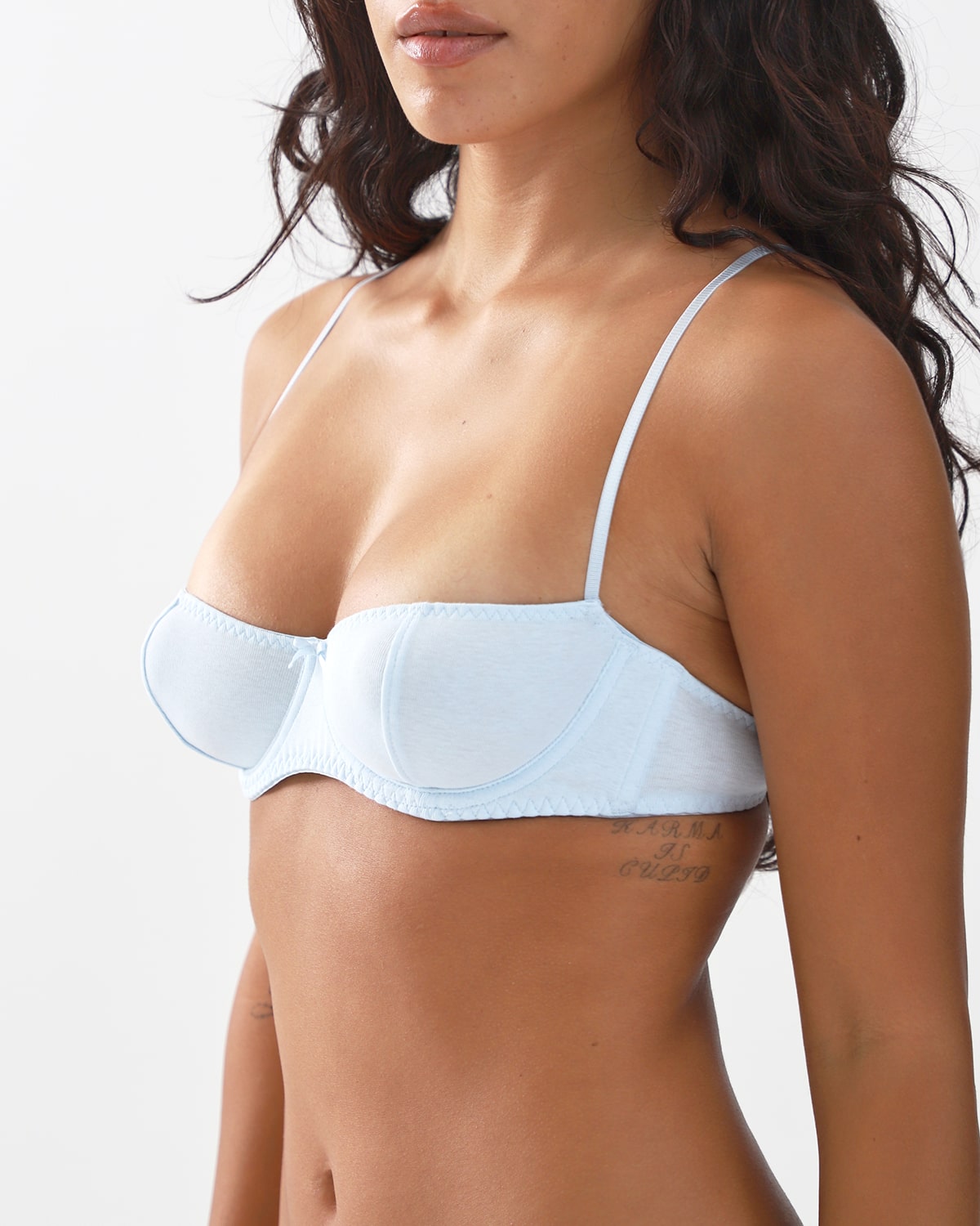 Light blue bra worn by a person on a white background