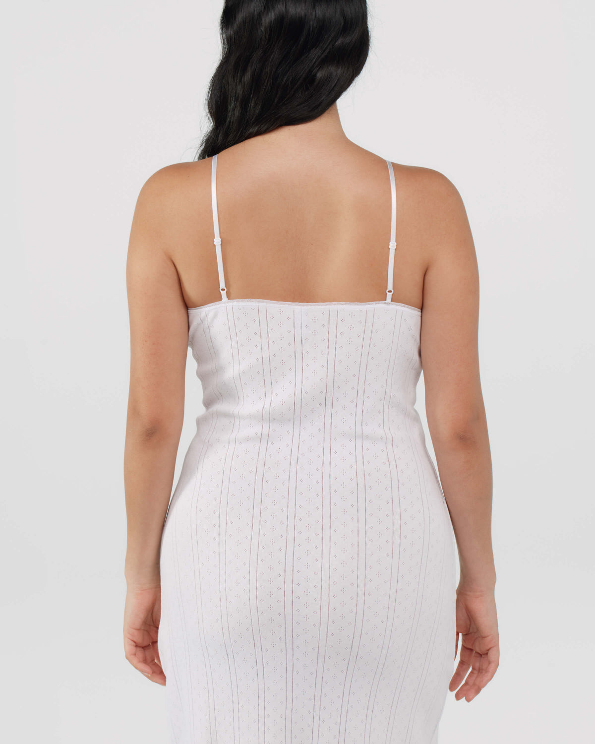 White slip dress worn by a person on a plain background