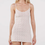Woman wearing a floral slip dress against a white background
