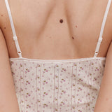 White floral camisole worn by a person on a neutral background