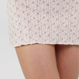 Floral patterned dress worn by a person on a plain background