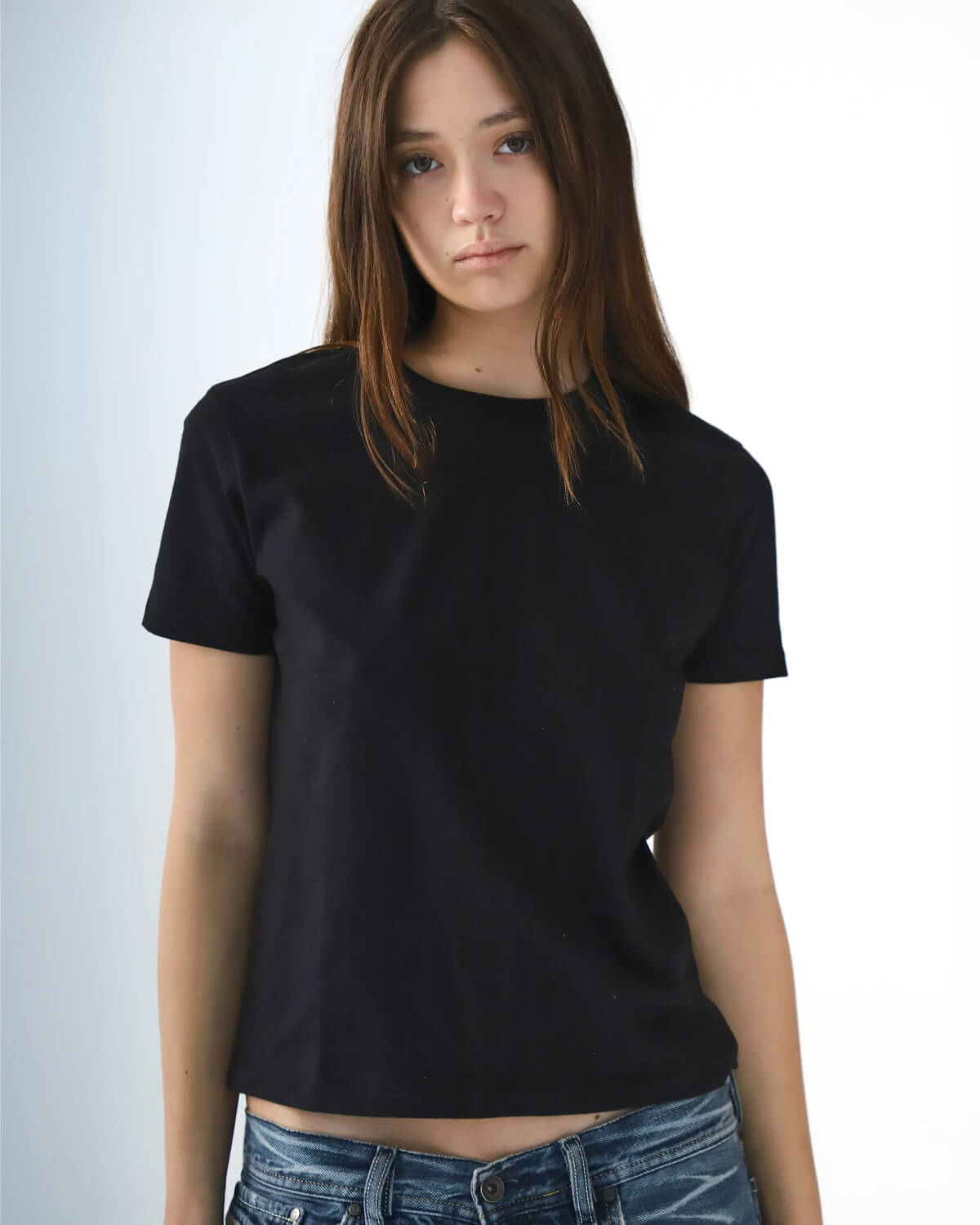 Person wearing a black t-shirt against a plain background