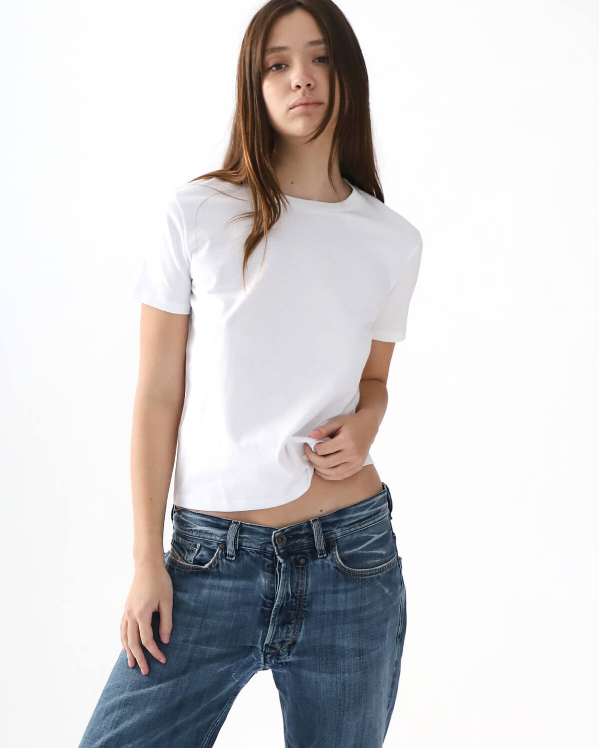 Person wearing a white t-shirt and blue jeans on a white background