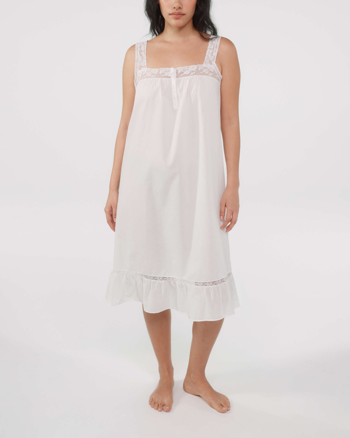 Woman wearing a white nightgown with lace details on a white background