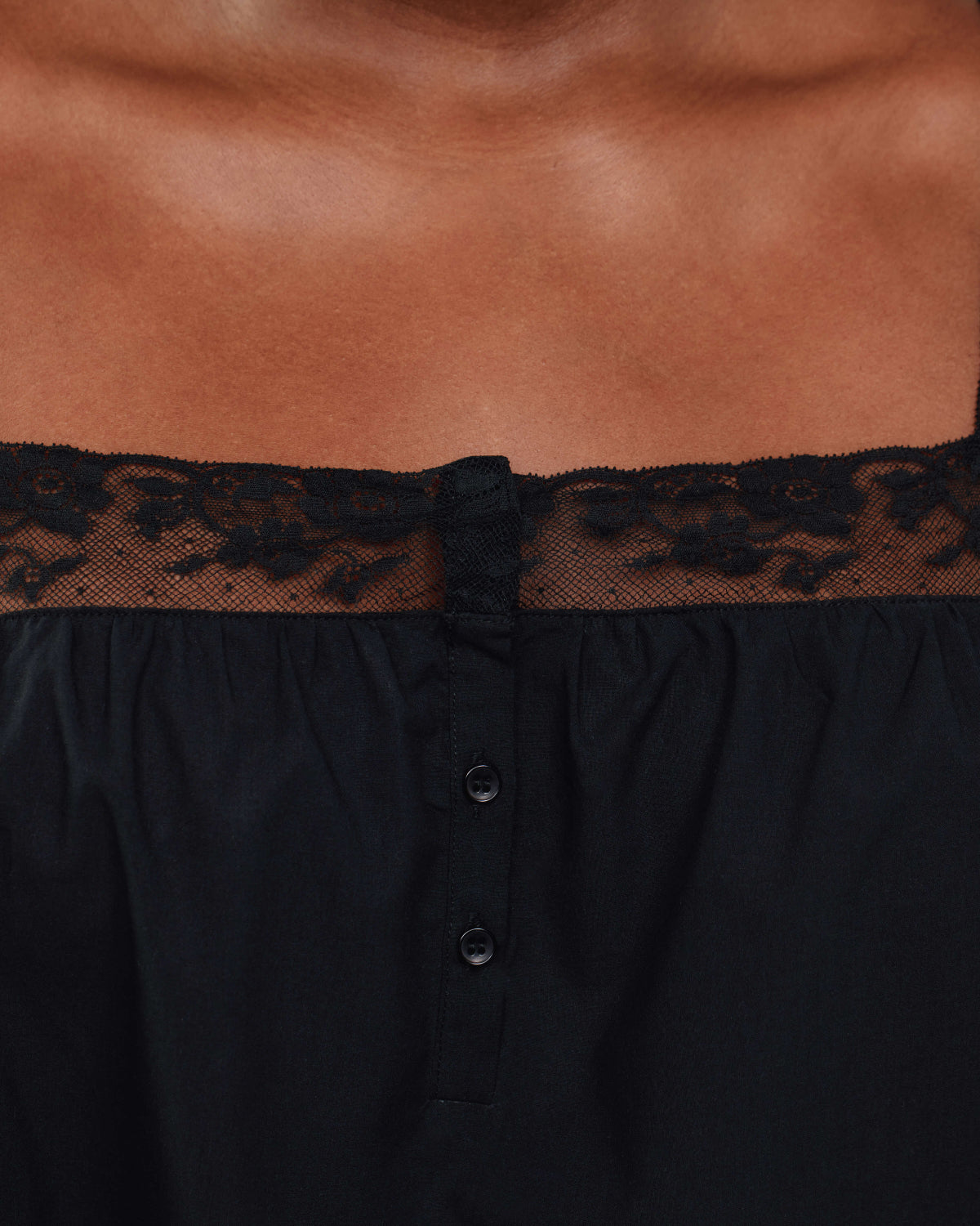 Black dress with lace trim on a brown background