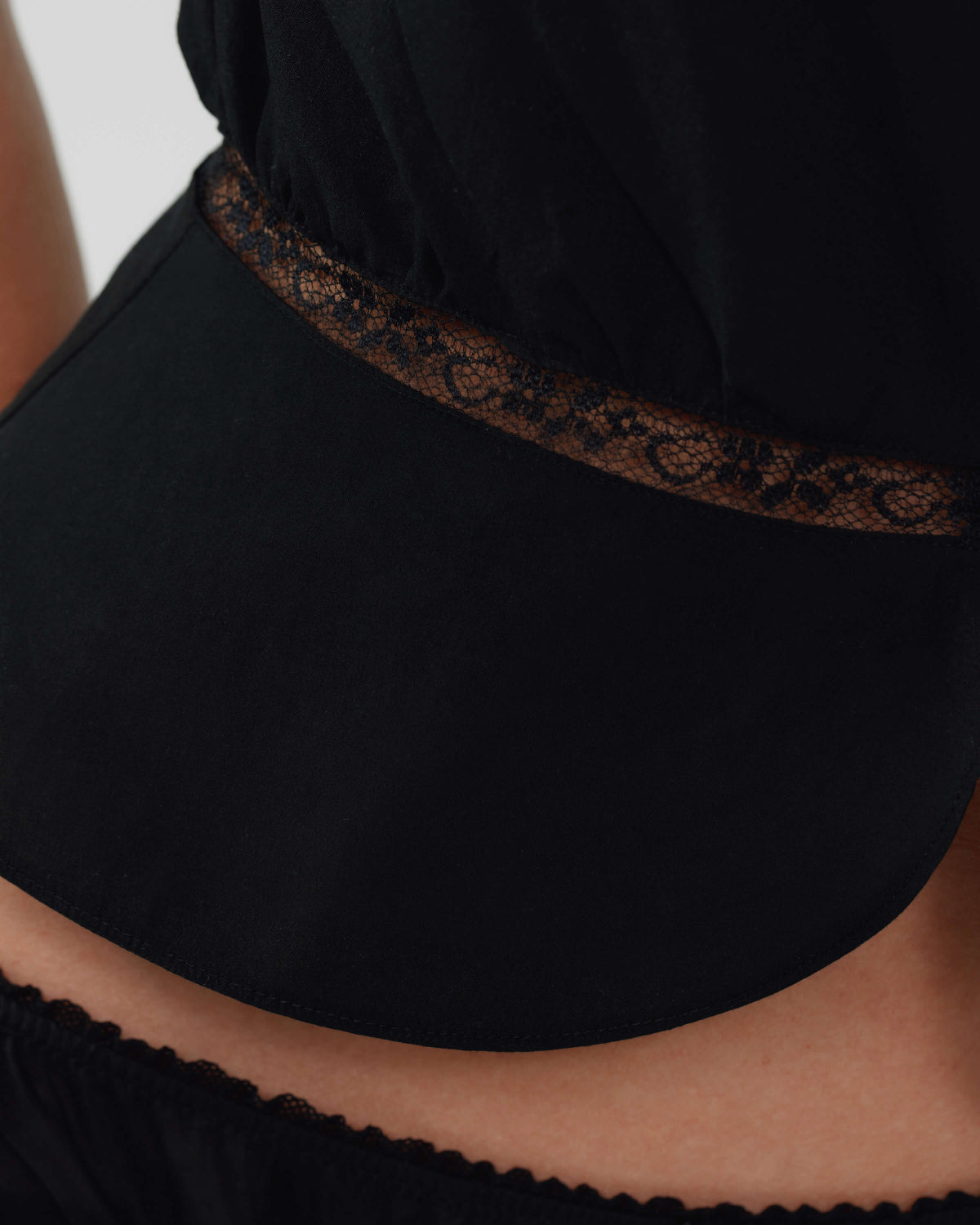 Black lace-trimmed top with a plain background