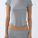 Person wearing a gray crop top and shorts on a white background