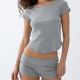 Woman wearing a gray t-shirt and shorts set on a white background