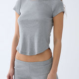 Person wearing a gray t-shirt and shorts set on a light gray background