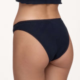 Rear view of a model wearing dark navy blue underwear against a plain off-white background.