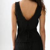 Black sleeveless top with lace detailing on a white background