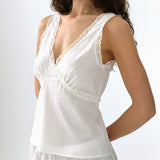 White lace-trimmed top worn by a model on a white background