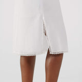White dress with lace trim on a plain background