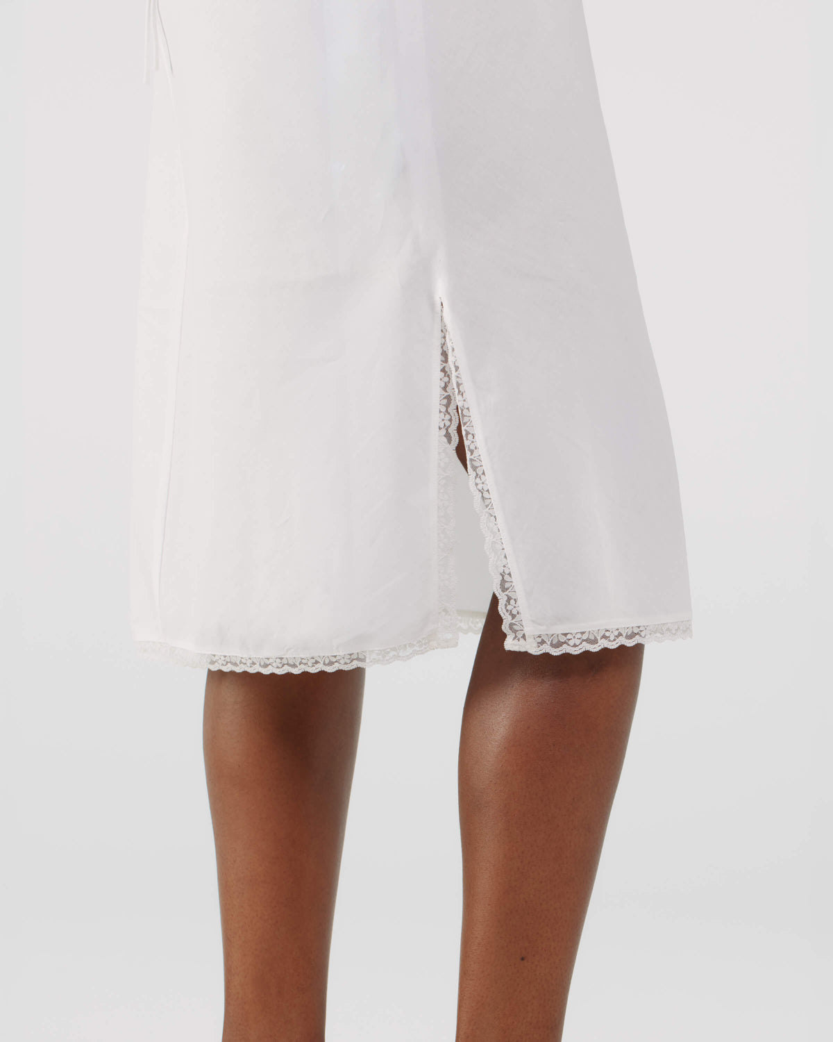 White dress with lace trim on a plain background