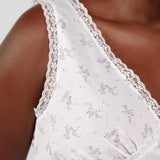 White lace-trimmed top with floral pattern on a plain background