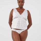 Woman wearing a white lace lingerie set on a plain background