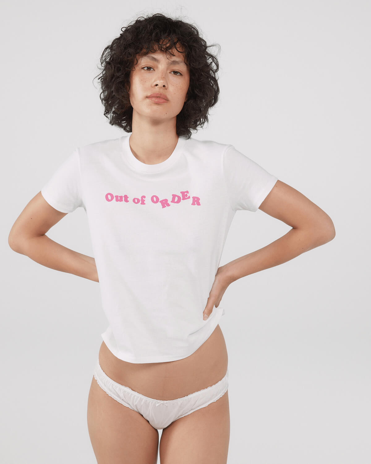 Person wearing a white t-shirt with 'Out of Order' text and white underwear.