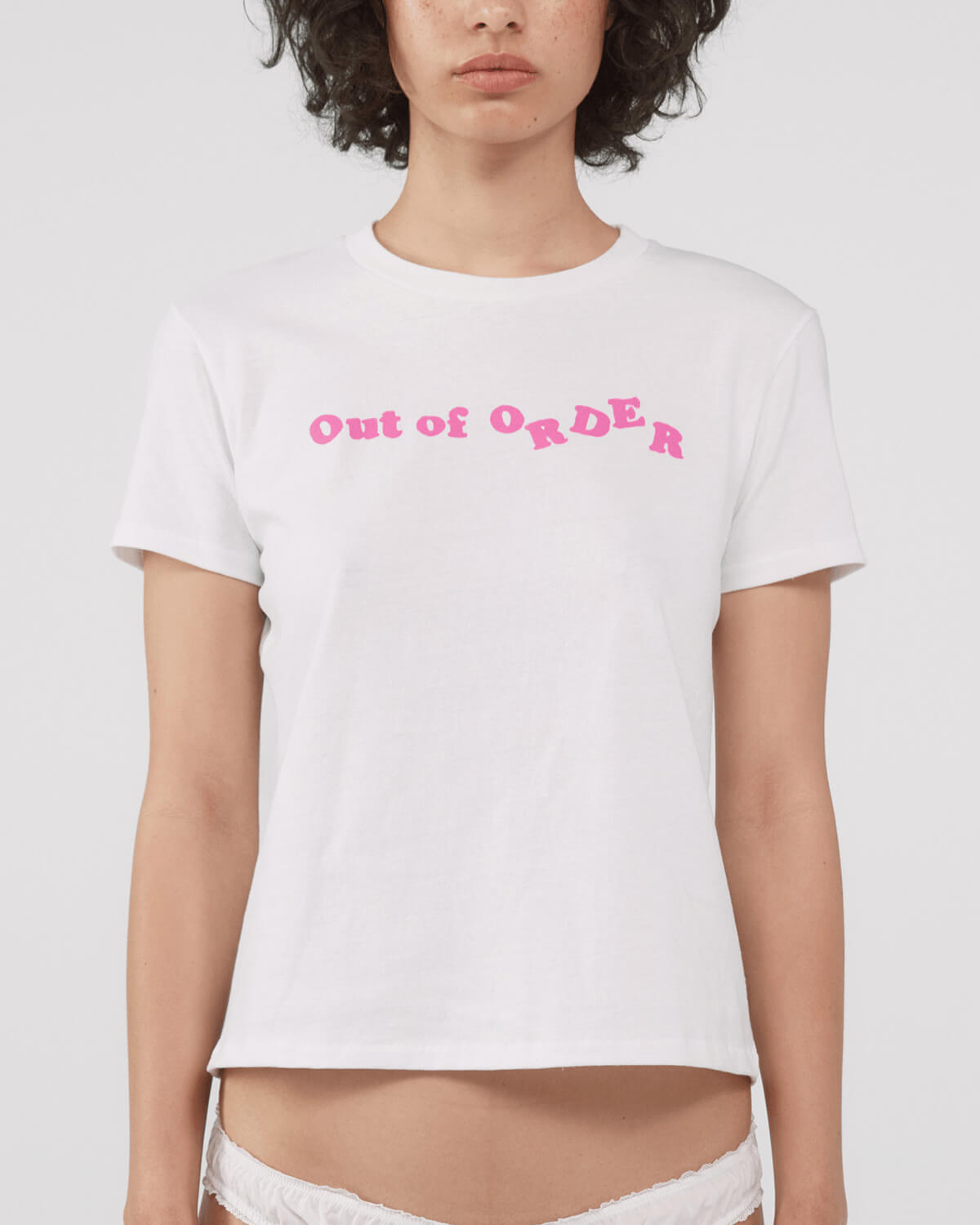 Person wearing a white t-shirt with pink text 'Out of Order' on a plain background