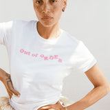 Person wearing a white t-shirt with 'Out of Order' text in pink on a plain background