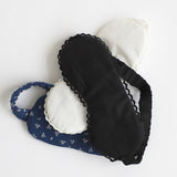 Black eye mask and blue headband with white floral pattern on a white background