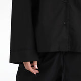 Close-up of a black shirt and pants on a white background