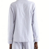 Person wearing a white and blue checkered pajama set on a white background