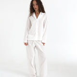 Woman wearing a white pajama set on a white background