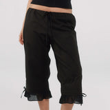 Black capri pants with ruffled hem on a white background