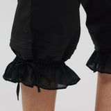 Black ruffled shorts with a plain background