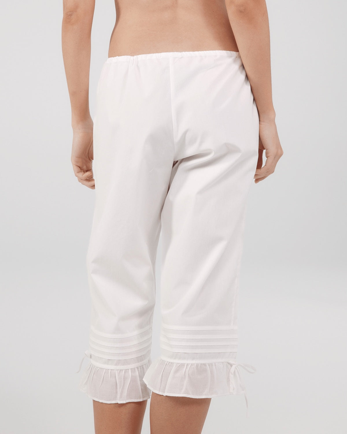 White capri pants worn by a person on a plain background