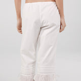White capri pants worn by a person on a plain background