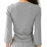 Gray long-sleeve top worn by a person on a white background