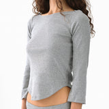 Gray long-sleeve top worn by a person on a white background