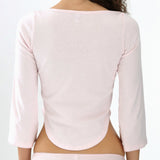 Person wearing a light pink long-sleeve top and underwear set on a white background