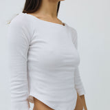 White long-sleeve crop top worn by a person on a plain background
