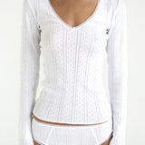 White ribbed long-sleeve top and underwear set on a white background