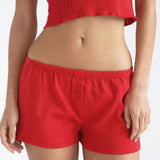 Person wearing red shorts on a white background