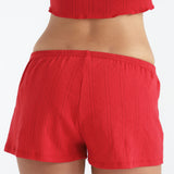 Red shorts worn by a person on a white background